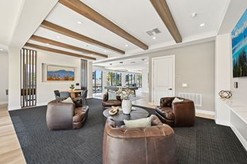 A spacious living room with brown leather furniture and a painting on the wall at The Concord Luxury Apartments, Sarasota, FL, 34240